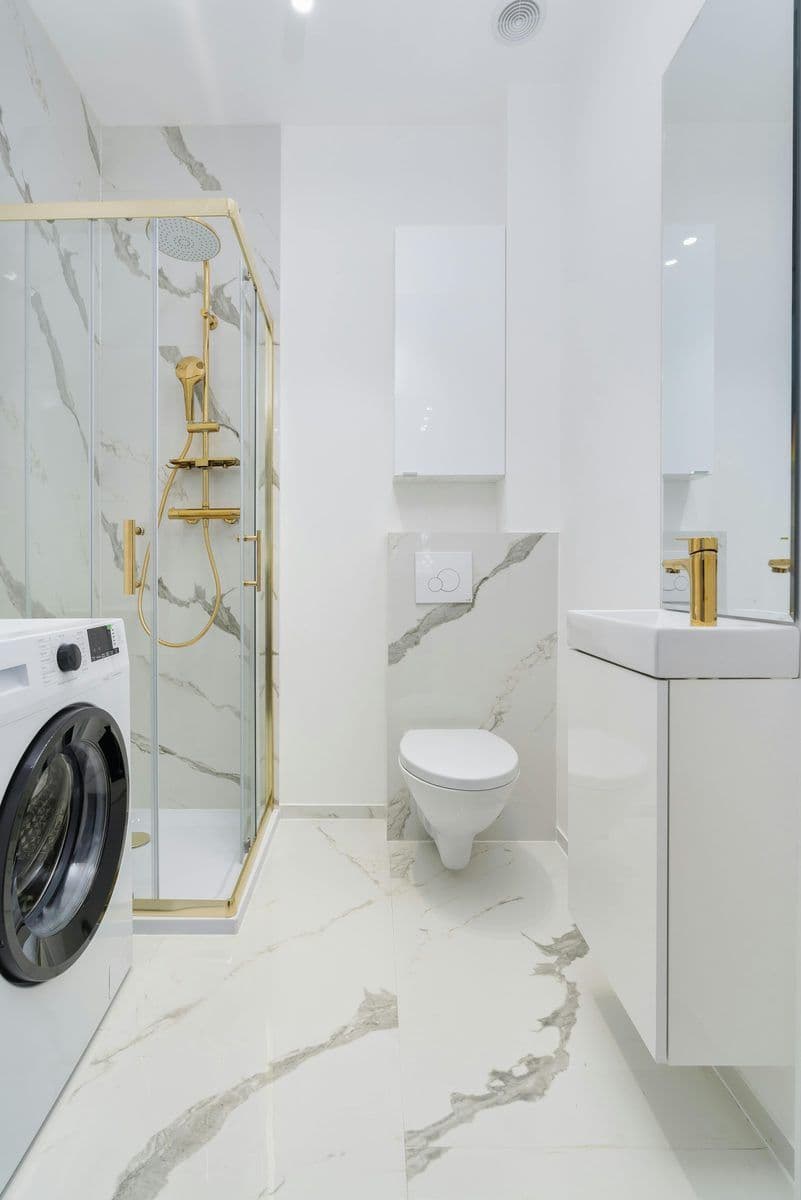 Shower enclosure with gold fittings and marble tiles