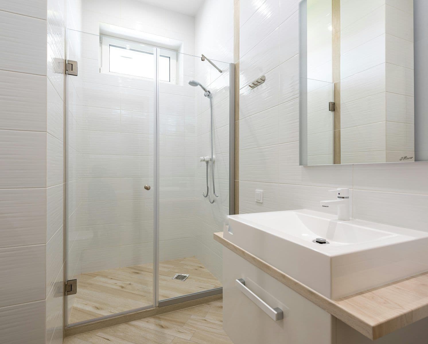 Glass shower enclosure door in a white bathroom
